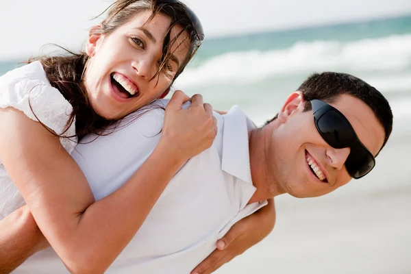 Пара улыбается на пляже — стоковое фото