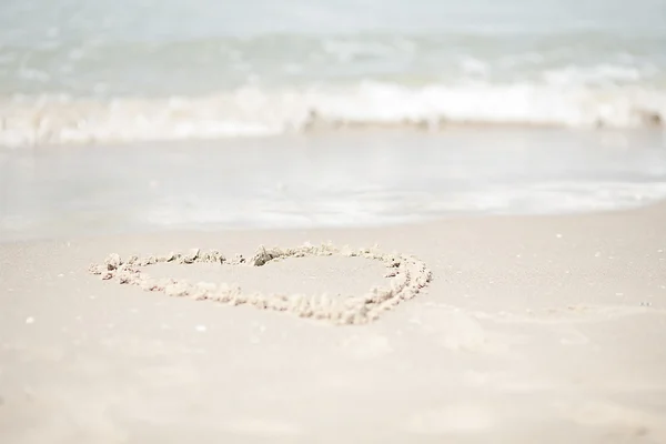 Corazón dibujando en la arena con olas marinas — Foto de Stock