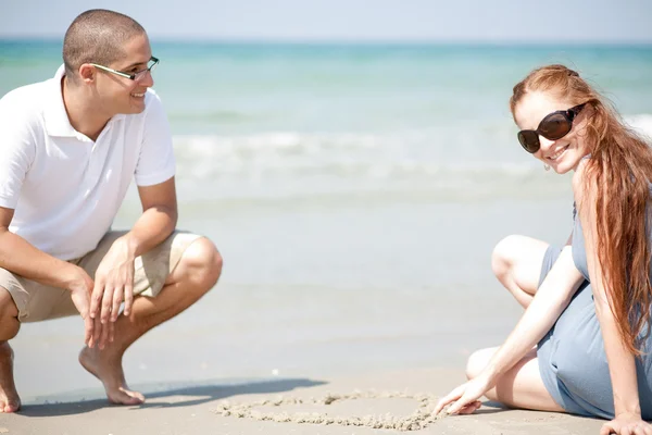 Genç çift sahilde siting sevgi dolu — Stok fotoğraf