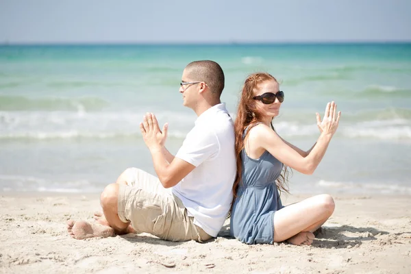 Casal fazendo exercícios na areia da praia — Fotografia de Stock