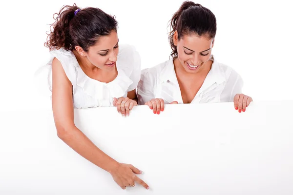 Mulheres aponta placa em branco para outro — Fotografia de Stock