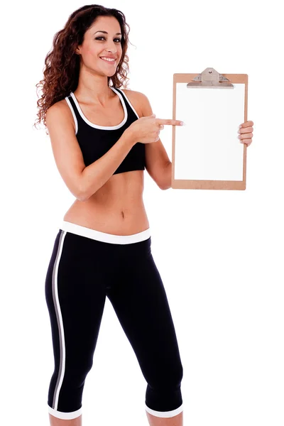 Mulher fitness mostrando uma placa de clipe em branco — Fotografia de Stock