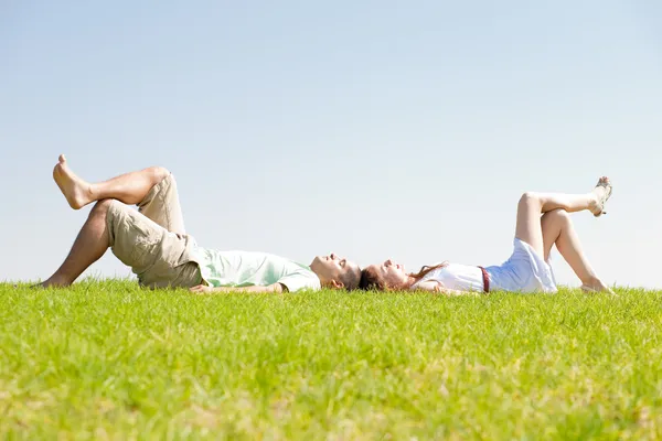 Couple lie down on grass Royalty Free Stock Photos