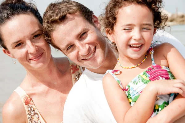 Kid and parents smiling in the beach — Stock Photo, Image