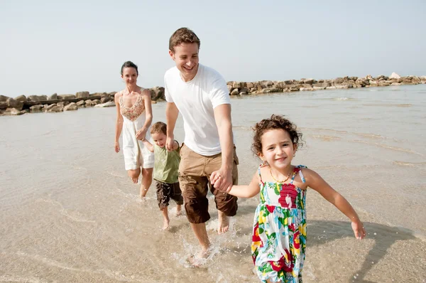 Діти насолоджуються з батьками на пляжі — стокове фото