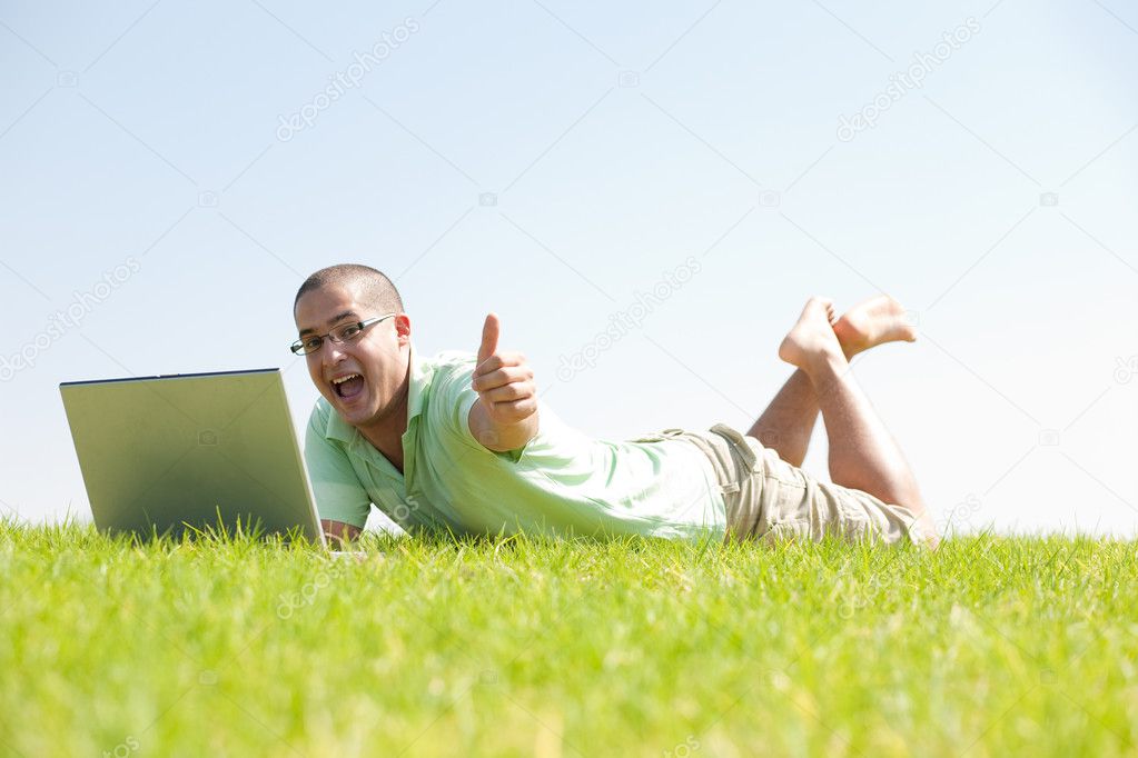 A young men on park using laptop