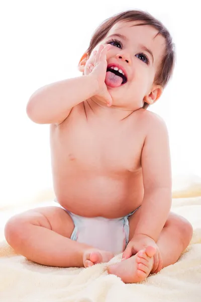 Ребенок сидит и улыбается с открытым ртом — стоковое фото