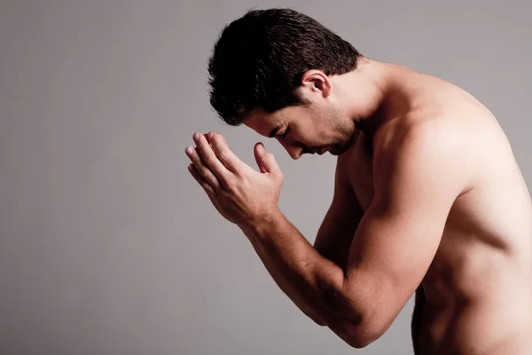 Мужчина без рубашки молится — стоковое фото
