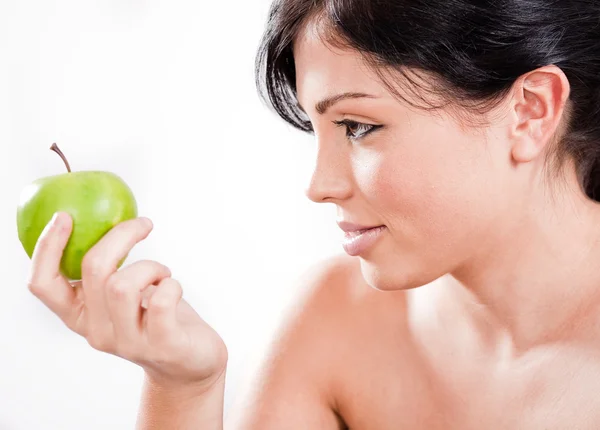 Schöne Frau hält einen grünen Apfel in der Hand — Stockfoto