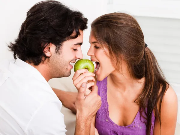 Junges Paar beißt in grünen Apfel — Stockfoto