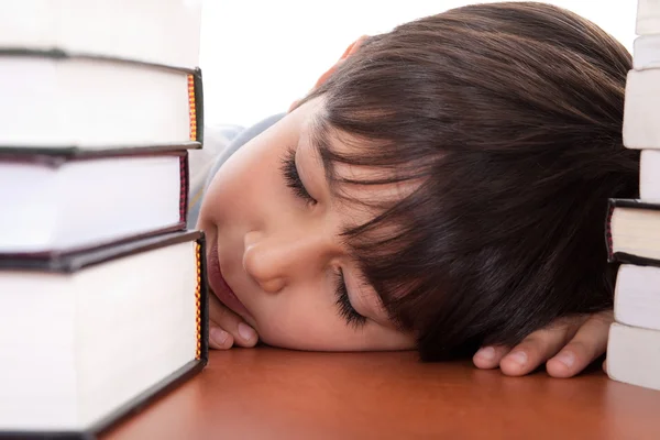 Boy tired of studying and sleeping — Stockfoto