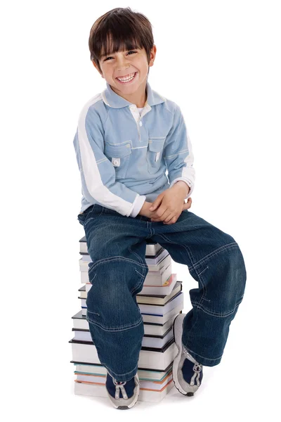 Jovem sentado sobre pilha de livros — Fotografia de Stock