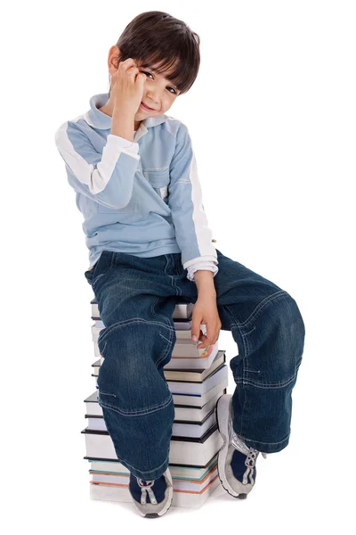 Мальчик, сидящий над башней книг — стоковое фото