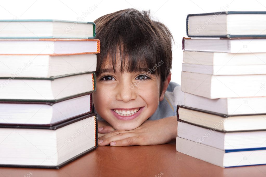 Young school boy surrounded by books