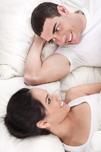 Χαμογελώντας ρομαντικό ζευγάρι ξαπλωμένο στο κρεβάτι — Φωτογραφία Αρχείου