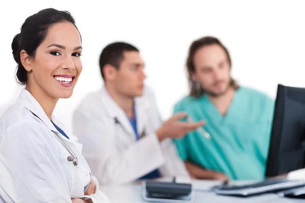 Jovem médico sorridente com outros médicos — Fotografia de Stock