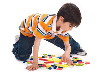 Cute kid inprocess of joining the blocks clipart