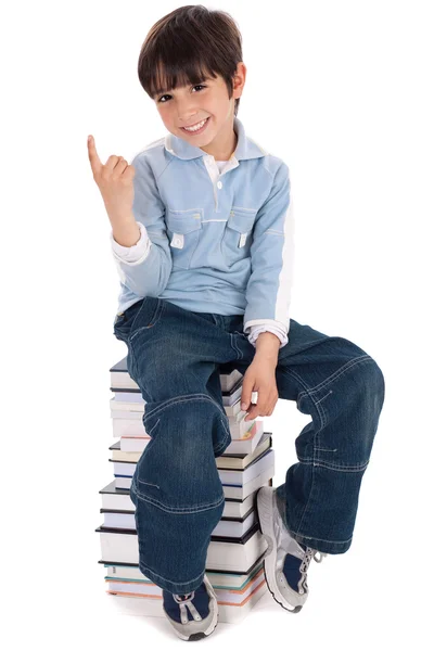 Jonge jongen zitten over toren van boeken — Stockfoto