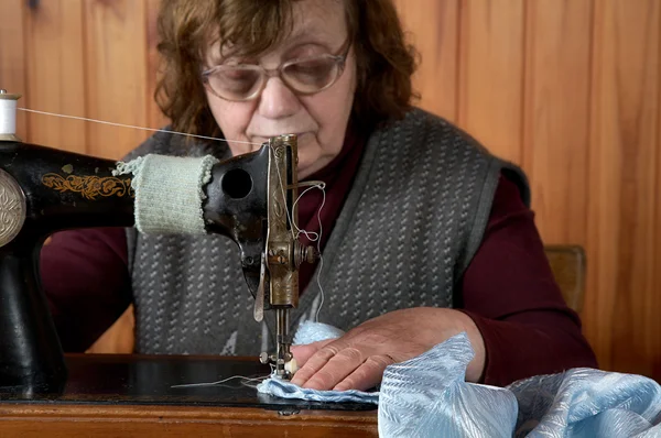 The old woman sews — Stock Photo, Image