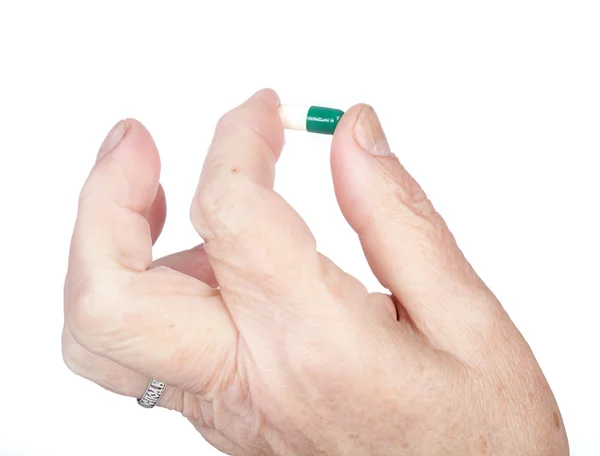 Hand of the old woman holds capsule with — Stock Photo, Image