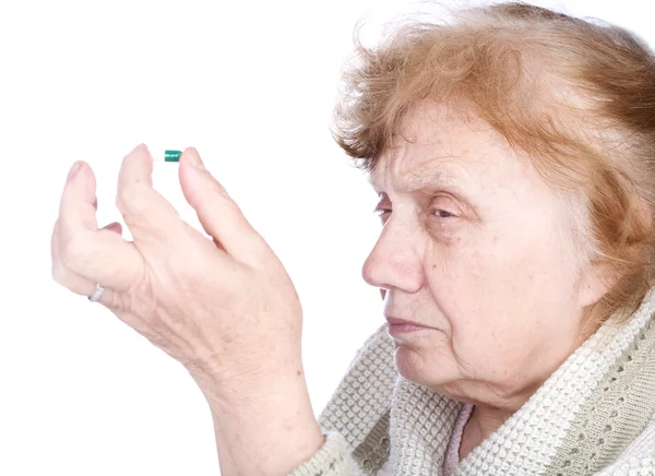 Yaşlı bir kadın tutan eller kapsül — Stok fotoğraf