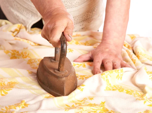 De oude vrouw strijkijzers een doek — Stockfoto