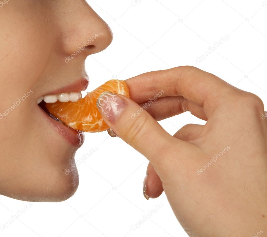 The girl biting a segment of tangerine