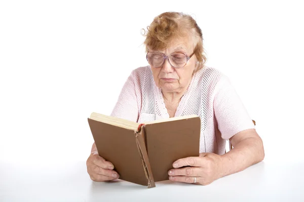 Velha mulher de óculos lê o livro — Fotografia de Stock