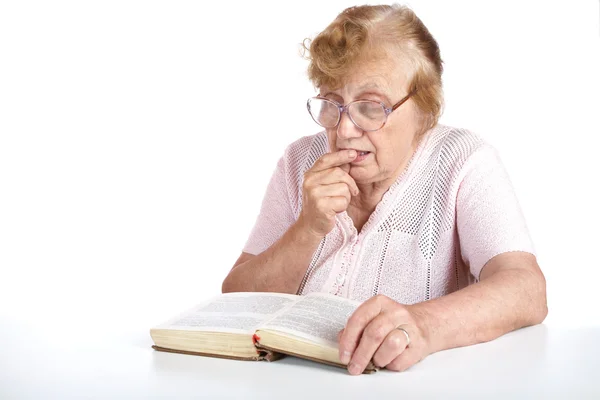 Oude vrouw in glazen leest het boek — Stockfoto