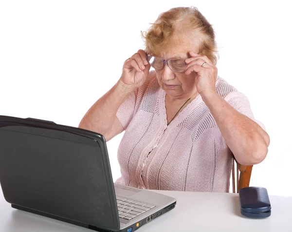 The old woman in glasses looks at the sc — Stock Photo, Image
