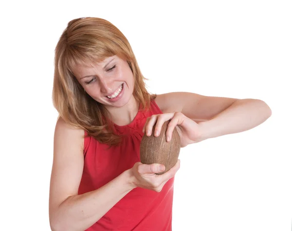 Pigen forsøger at bryde kokos - Stock-foto