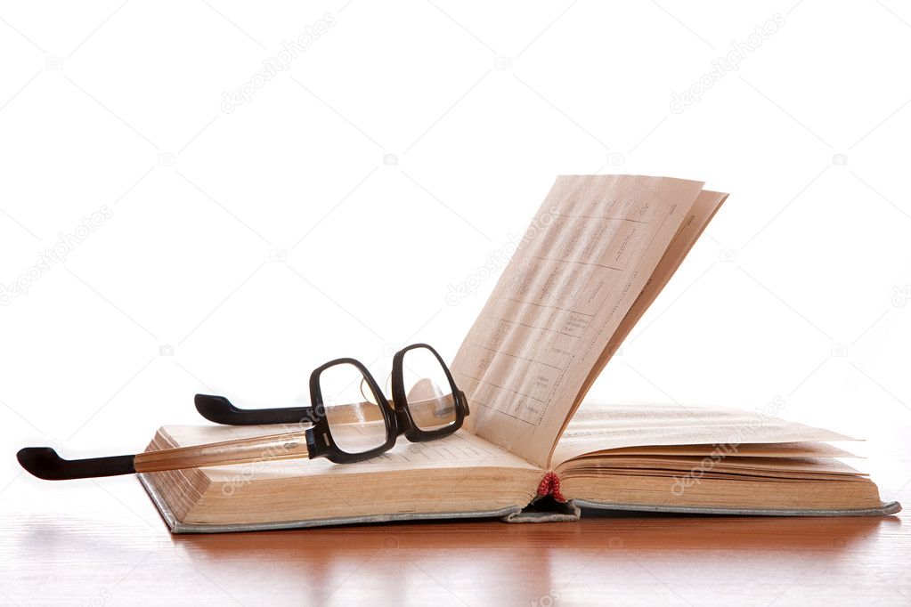Old glasses and the old book laying on a