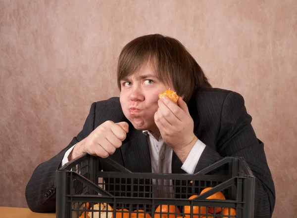 Młody człowiek zjada mandarynki — Zdjęcie stockowe