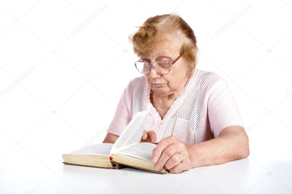 Old woman in glasses reads the book