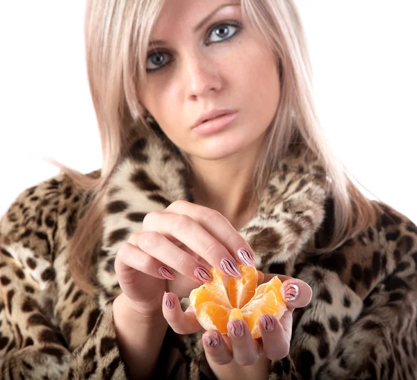 Girl in fur coat holds tangerine — Stock Photo, Image