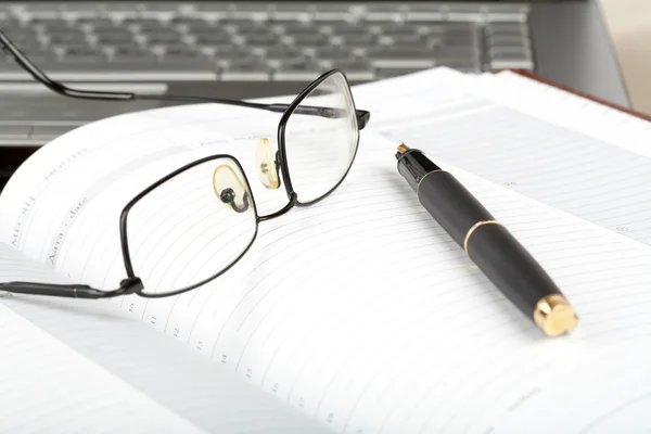 Организатор, очки, ручка и ноутбук — стоковое фото