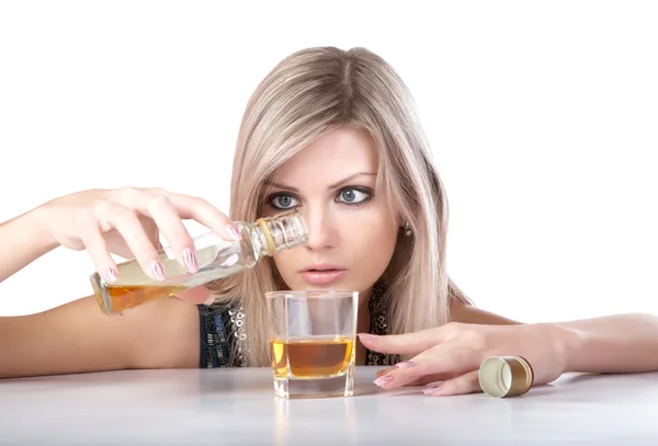 Das Mädchen gießt Whisky aus der Flasche — Stockfoto