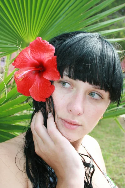 Девушка с тропическими цветами — стоковое фото