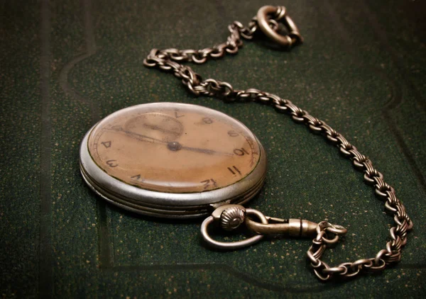 Παλιό ρολόι με αλυσίδα ξαπλωμένος στο τραχύ gree — Φωτογραφία Αρχείου