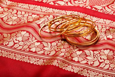 Indian sari with golden bangles clipart