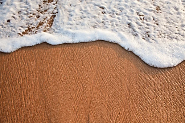 Wave surging on sand — Stock Photo, Image