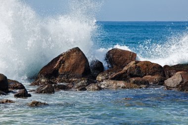 Waves breaking against the rocks clipart