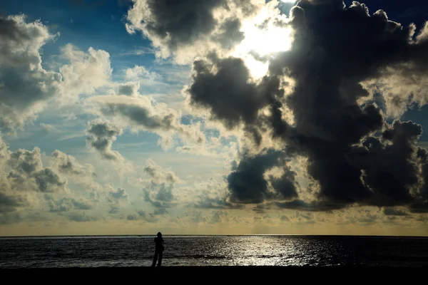 Man σιλουέτα στέκεται στην παραλία την ανατολή του ηλίου — Φωτογραφία Αρχείου