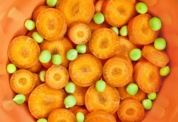 Cenoura e ervilhas verdes no artigo cerâmico — Fotografia de Stock