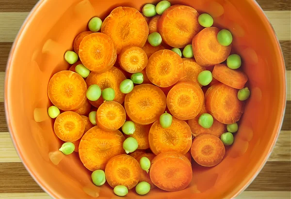 Karotten und grüne Erbsen im Keramikgeschirr — Stockfoto