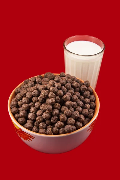 Glass with milk and chokolate balls — Stock Photo, Image