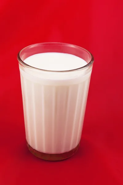 Склянка зі свіжим молоком, на чорній спині — стокове фото