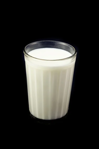 Стекло со свежим молоком, на черной спине — стоковое фото