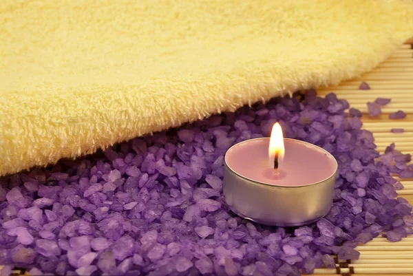 Куча фиолетовой соли для ванн и свечи — стоковое фото