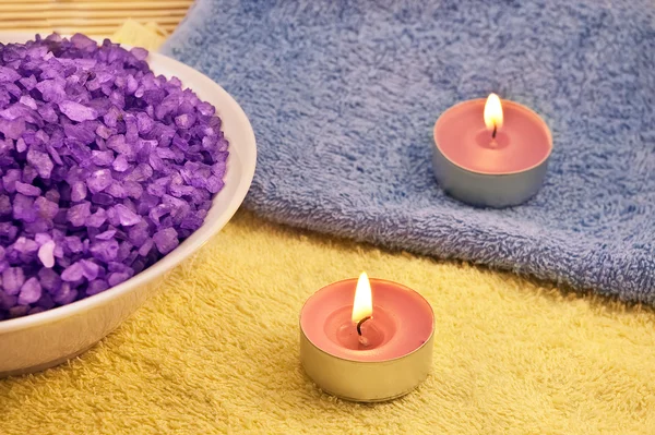 Tas de bain violet sel avec des bougies — Photo